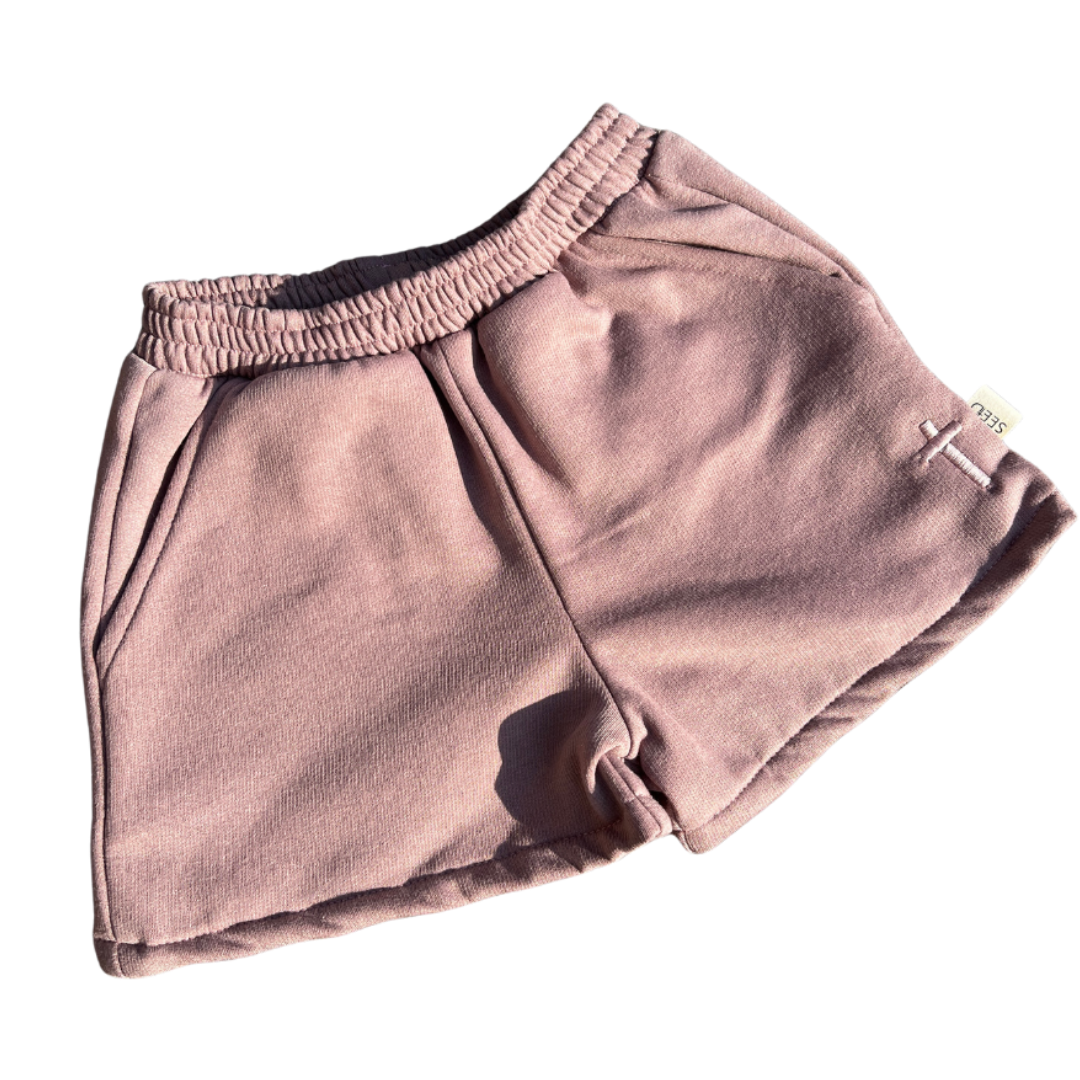 Folded pink shorts on a white background