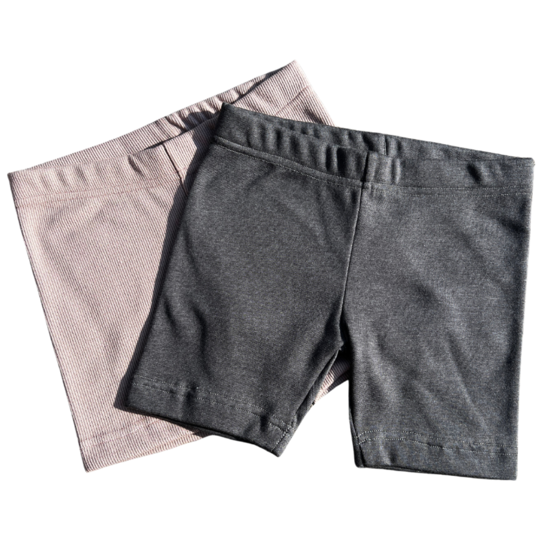 Two pairs of Leggings one gray and one Dusty pink, on a white background