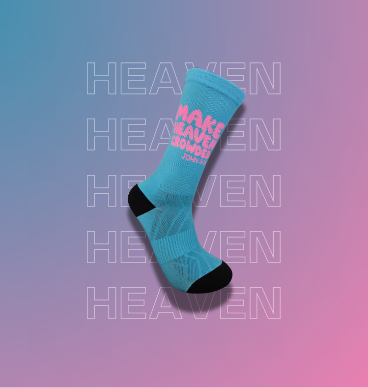 A single light blue crew sock with black toe and heel accents, featuring pink text that reads 'MAKE HEAVEN crowded', shown on a pink-to-blue gradient background with repeated faint 'HEAVEN' text.