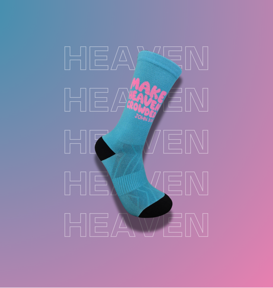 A single light blue crew sock with black toe and heel accents, featuring pink text that reads 'MAKE HEAVEN crowded', shown on a pink-to-blue gradient background with repeated faint 'HEAVEN' text.